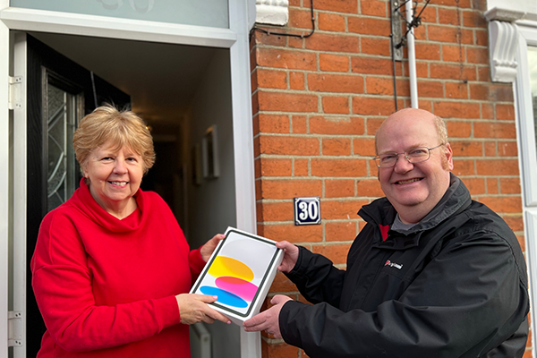 Beverley takes delivery of her iPad from Martin Cook of the Red Rose Labour Tote